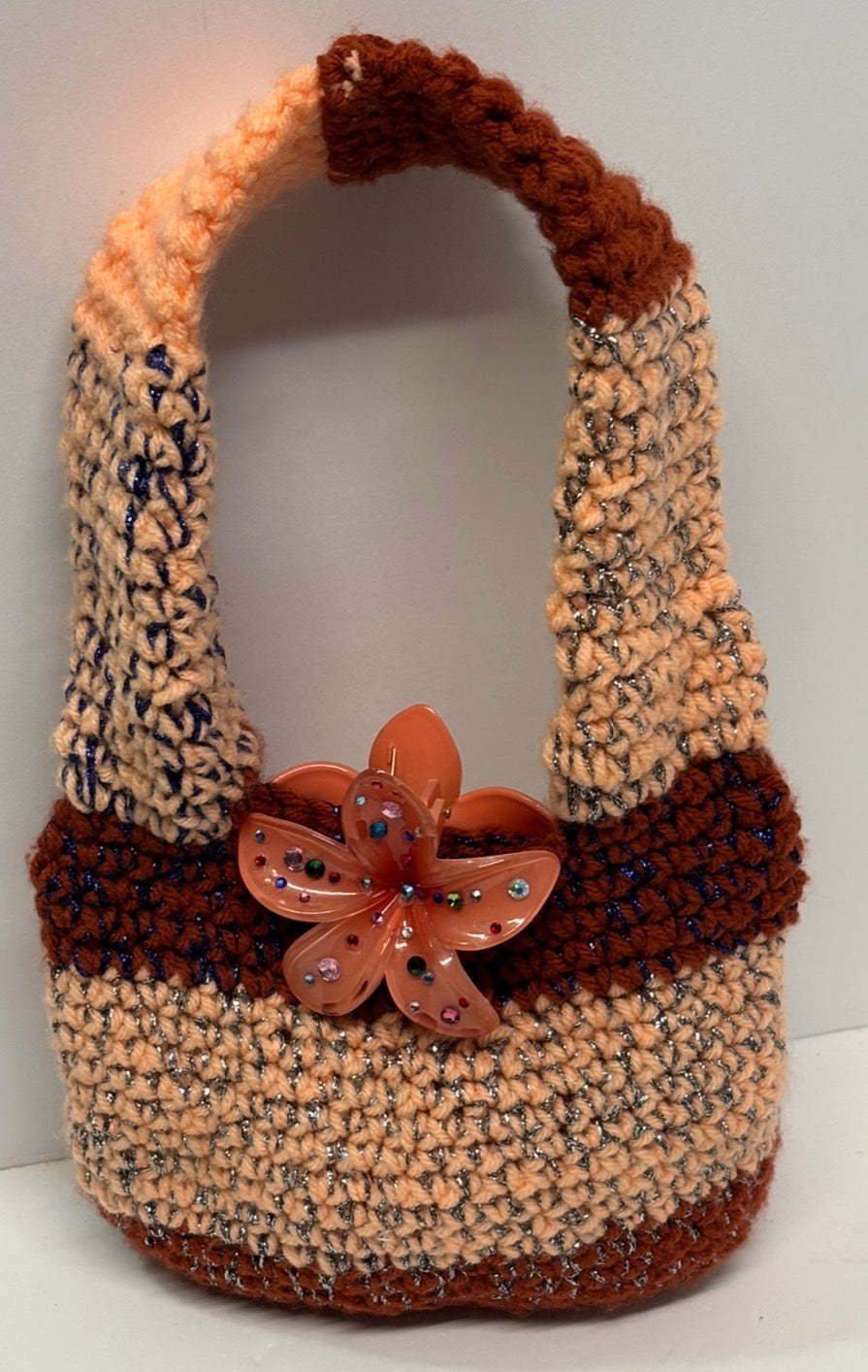 Orange and brown handmade crochet handbag with a flower detail