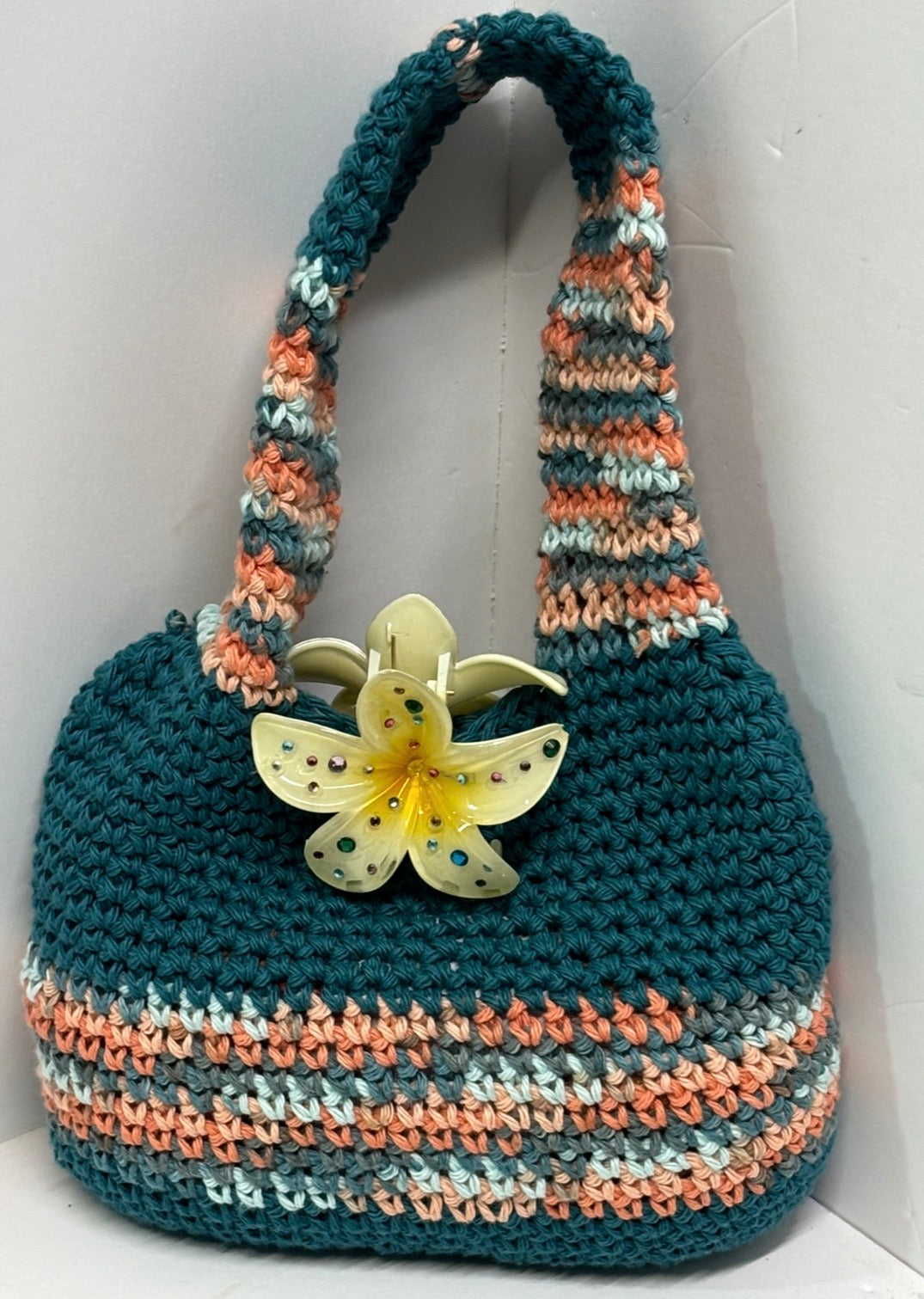 Teal handmade crochet handbag with a flower detail